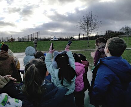 Children waving at the helicopter as it arrives